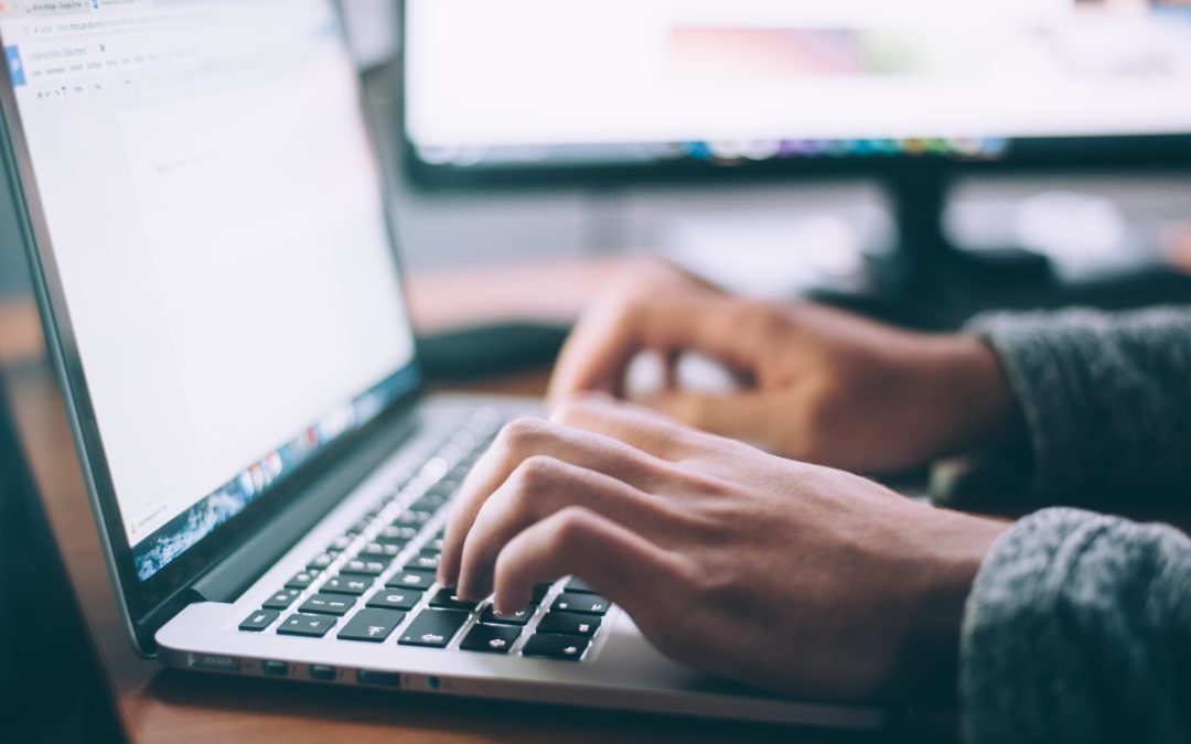 man typing on laptop